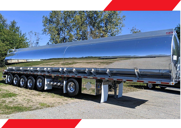 A large long trailer is parked on the side of the road.